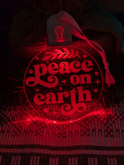 Laser-engraved Peace on Earth acrylic bauble displaying multi-colour LED lighting