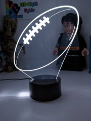 AFL ball Shape 3D LED night light glowing softly in a child’s bedroom with remote control.