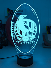 Collingwood Magpies 3D LED night light glowing softly in a child’s bedroom with remote control.