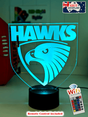 Hawthorn Hawks 3D LED night light glowing softly in a child’s bedroom with remote control.