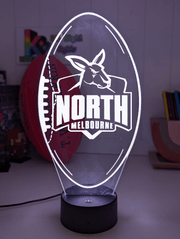 North Melbourne Kangaroos 3D LED night light glowing softly in a child’s bedroom with remote control.