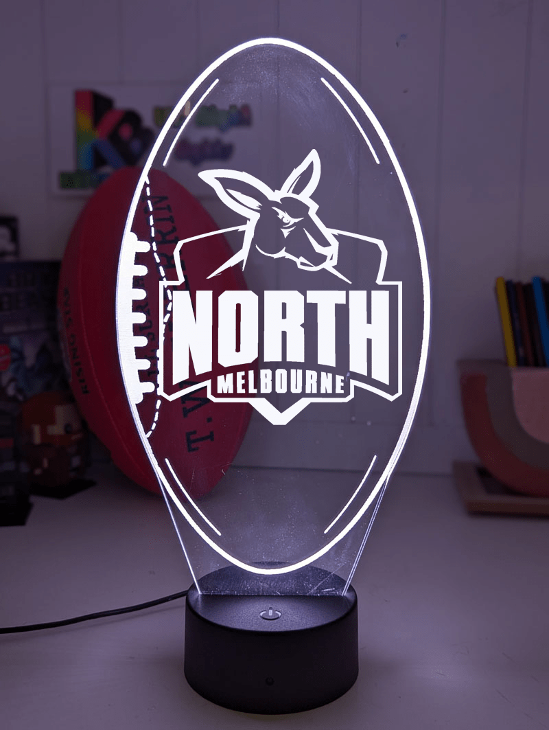North Melbourne Kangaroos 3D LED night light glowing softly in a child’s bedroom with remote control.