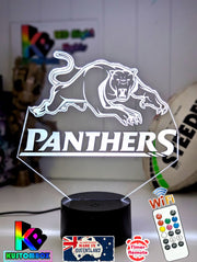 3D LED night light with a plaque featuring the Penrith Panthers rugby team logo, illuminated in white, on a black base with a USB power cord and a remote control.