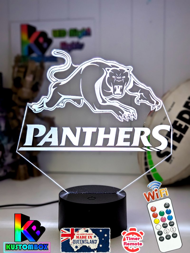 3D LED night light with a plaque featuring the Penrith Panthers rugby team logo, illuminated in white, on a black base with a USB power cord and a remote control.